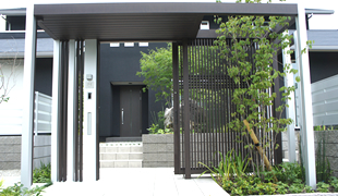 黒い建物に合わせて、新しい門のスタイルとして人気が高いアルミフレームで立体的に組んだアーチ。